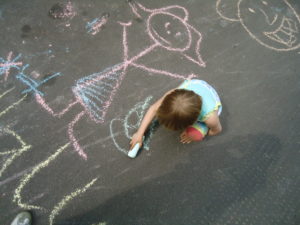 Temporäre Spiel- und Nachbarschftsstraße - Kind malt mit Kreide